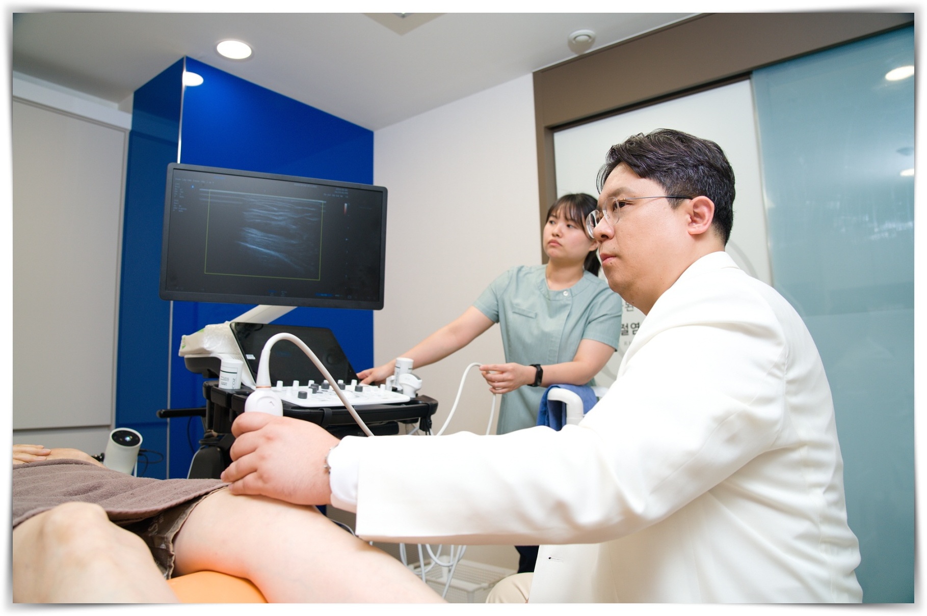 무릎 관절 초음파 검사를 진행하는 의사의 모습